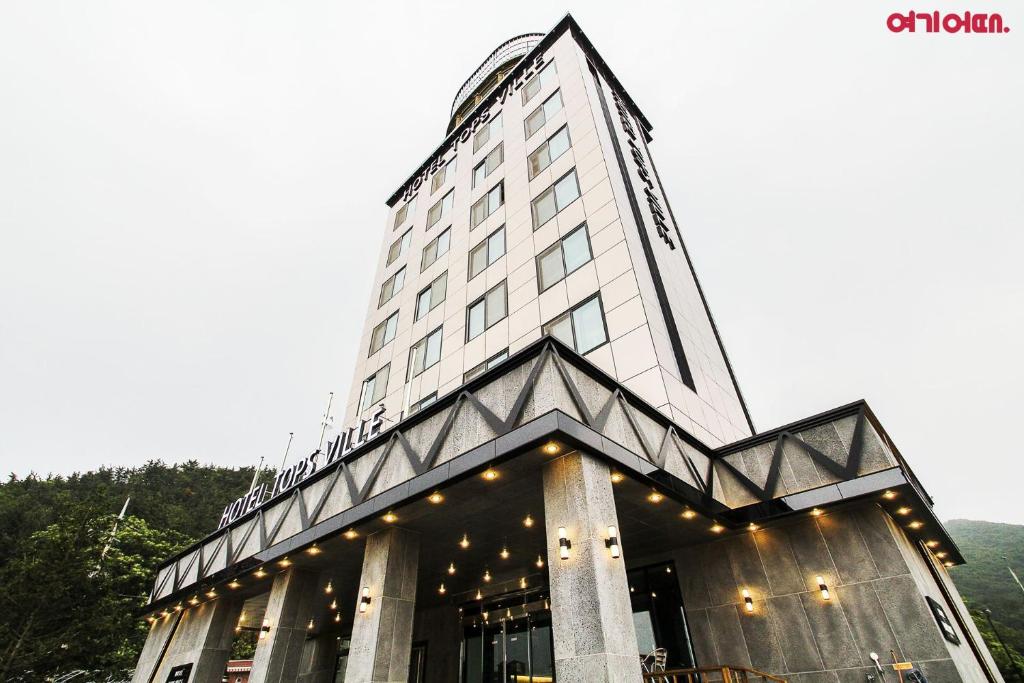 Hotel TopsVille في جانجنيونج: مبنى طويل وبه أضواء فوقه