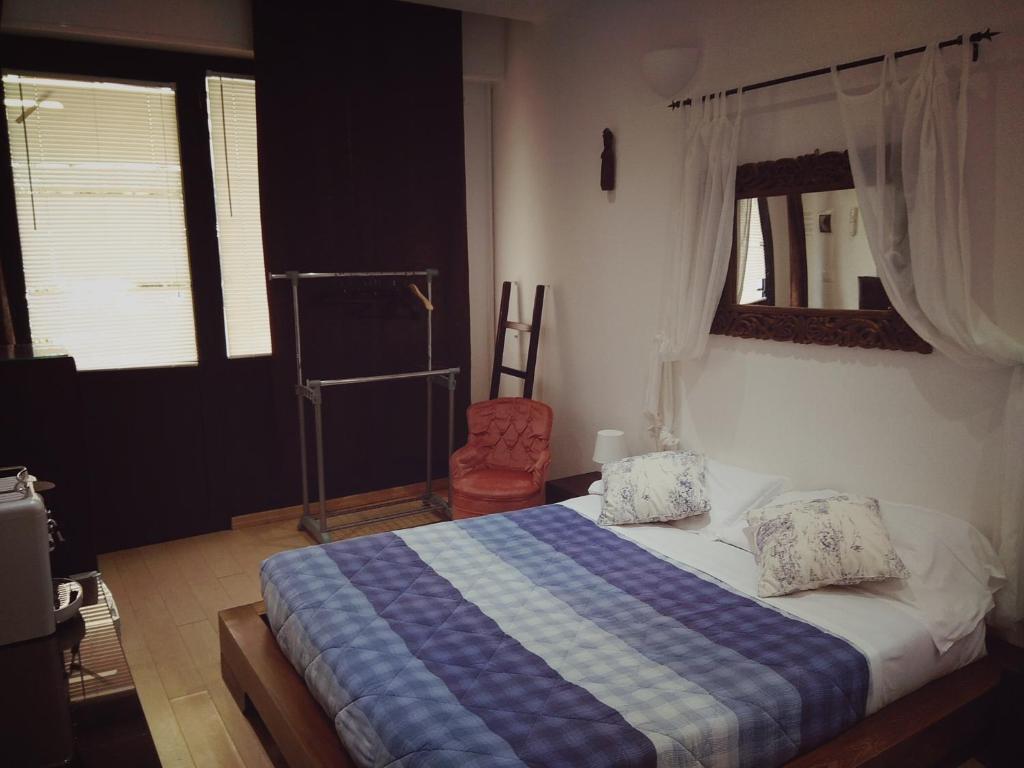 a bedroom with a bed with a blue and white blanket at B&B The Dream in Zoagli