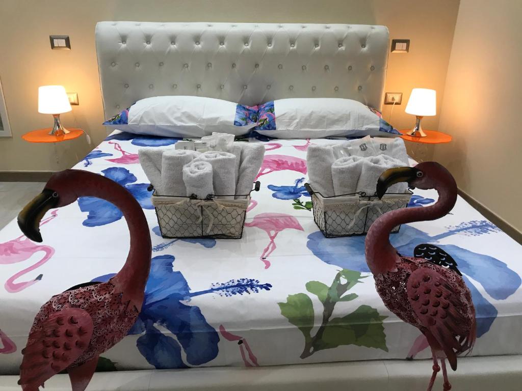 dwóch flamingów stojących na łóżku w sypialni w obiekcie Flamingo Luxury Apartment AJPSARDINIA w Cagliari