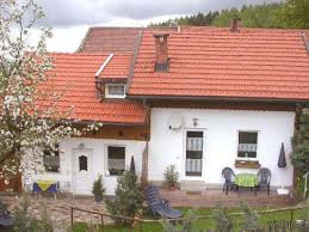 una casa blanca con techo naranja en Ferienwohnung Am Zechenhaus en Bodenmais