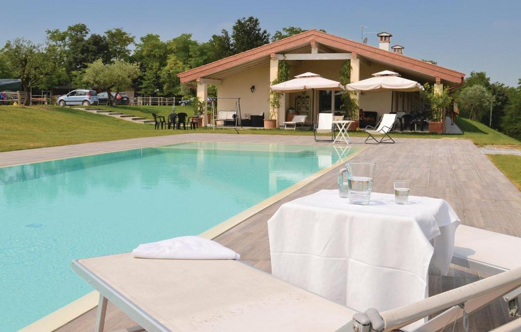 a swimming pool with a table and a house at Agriturismo Colle Dei Pivi in Ponti Sul Mincio