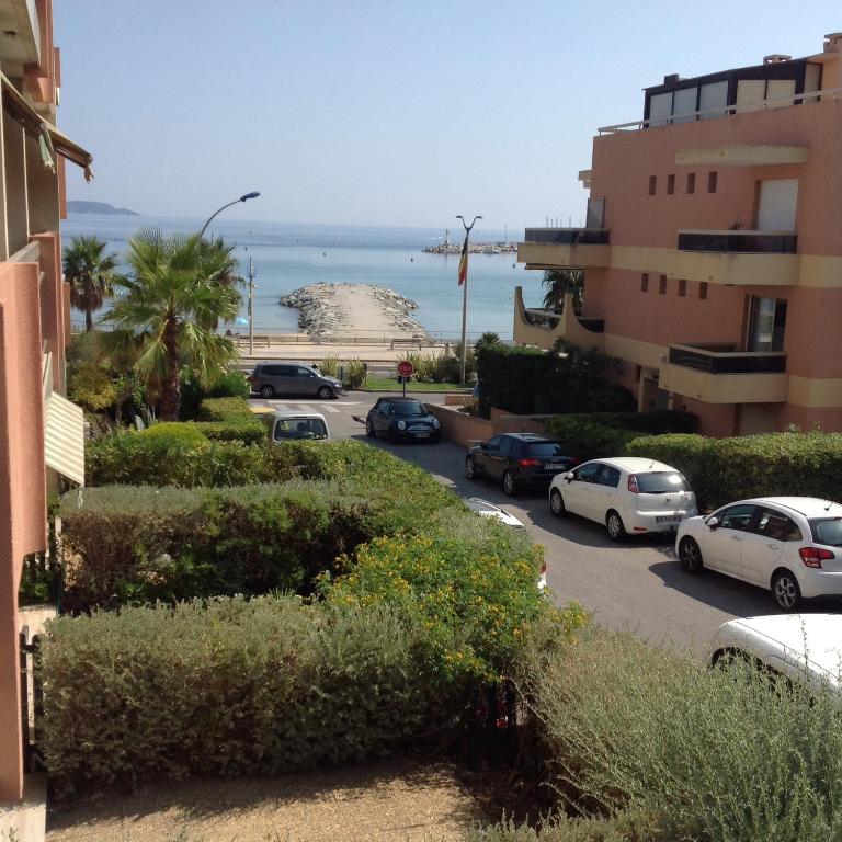 um parque de estacionamento com carros estacionados ao lado de uma praia em Cavalaire chez Michelle em Cavalaire-sur-Mer