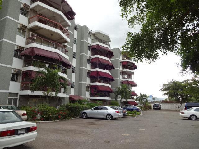 a large apartment building with cars parked in a parking lot at Worthington Towers Apartment in Kingston