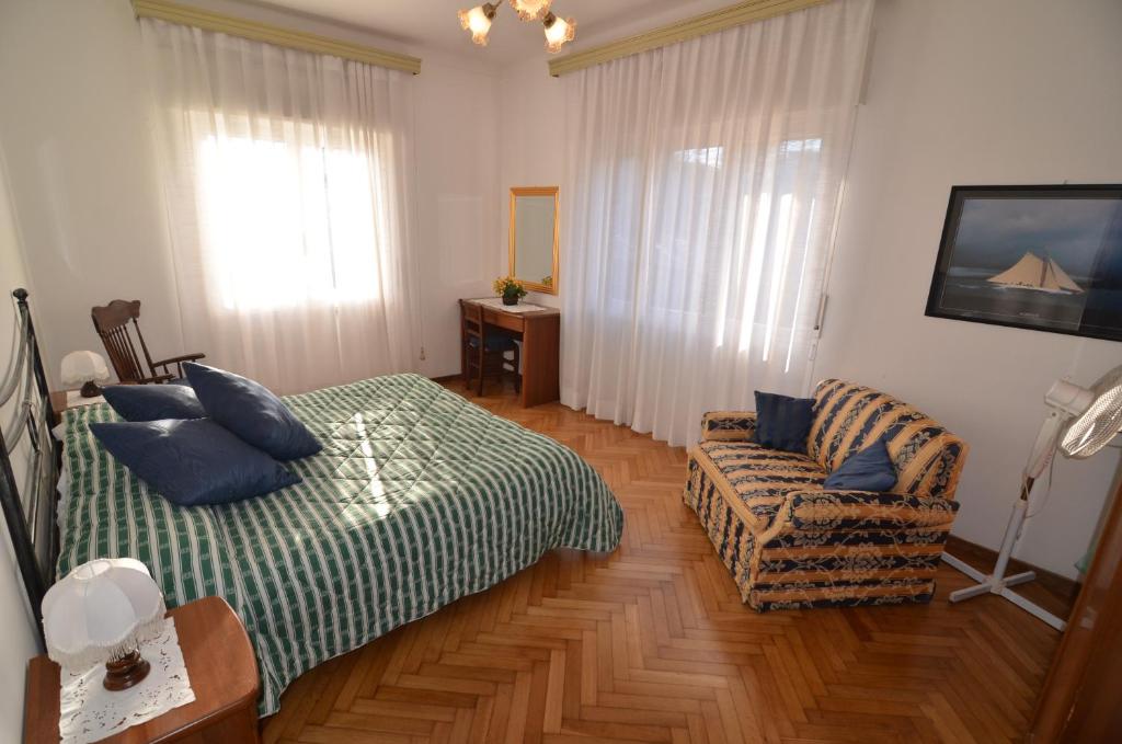 um quarto com uma cama, um sofá e uma janela em Glicine apartment em Levanto
