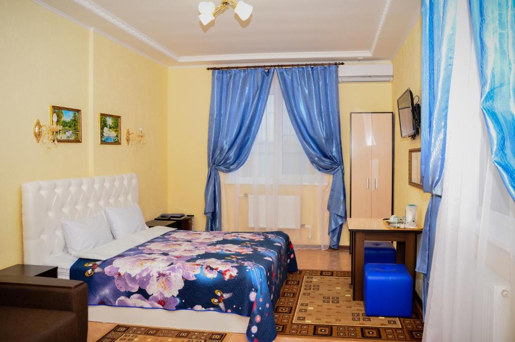 a bedroom with a bed and blue curtains and a window at Домодедово-Александрия in Domodedovo