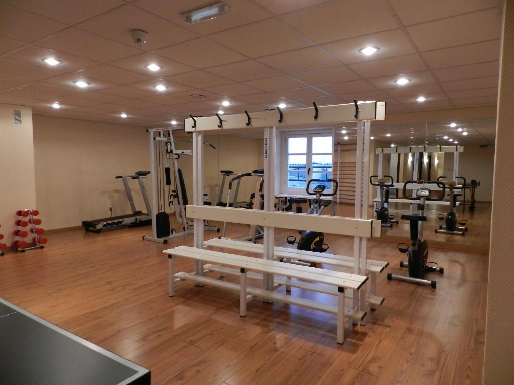 a gym with several treadmills and machines in a room at Parador de Vilalba in Villalba