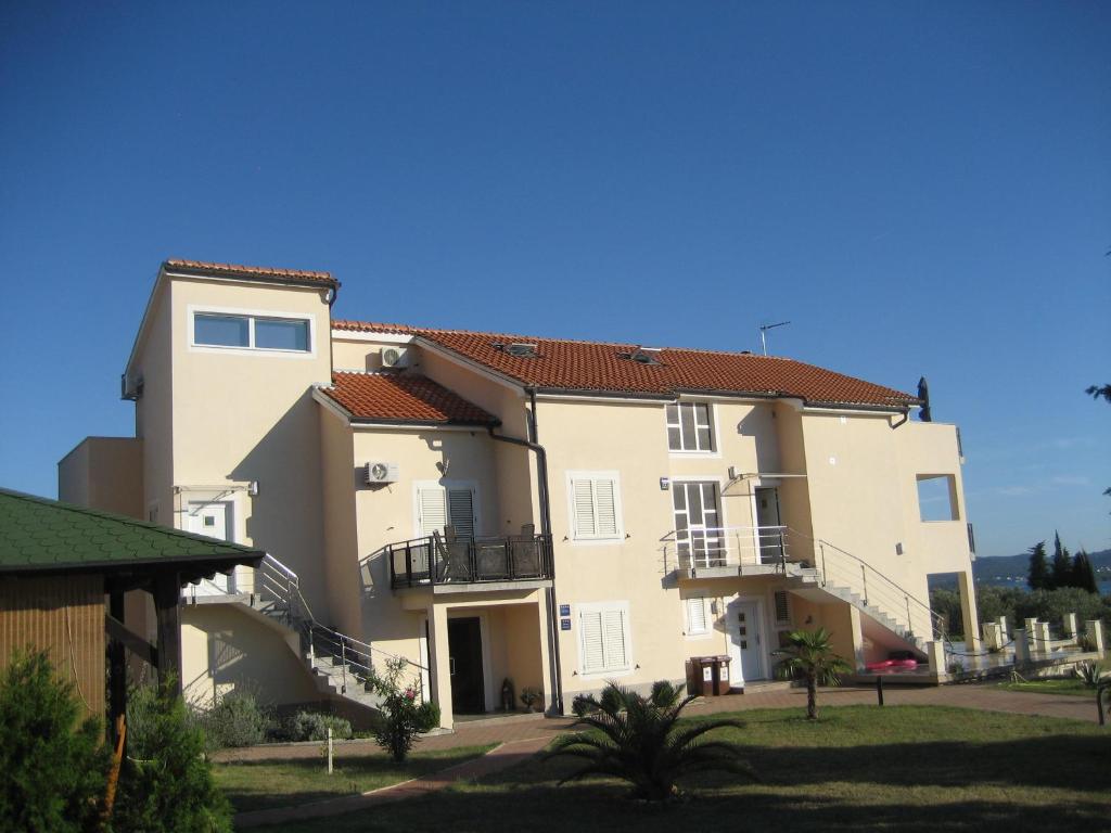 ein großes Apartmenthaus mit Balkon und Hof in der Unterkunft Villa „Drei Palmen“ in Sveti Filip i Jakov