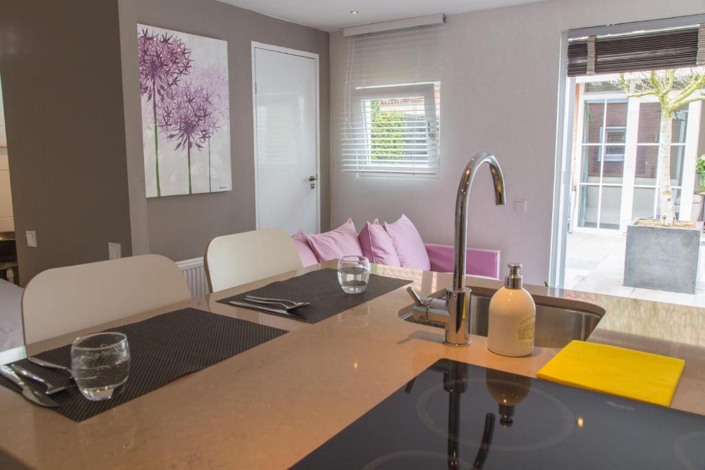 a kitchen with a counter top with a sink and a table at Bed & Bike Studio Amsterdam in Amsterdam