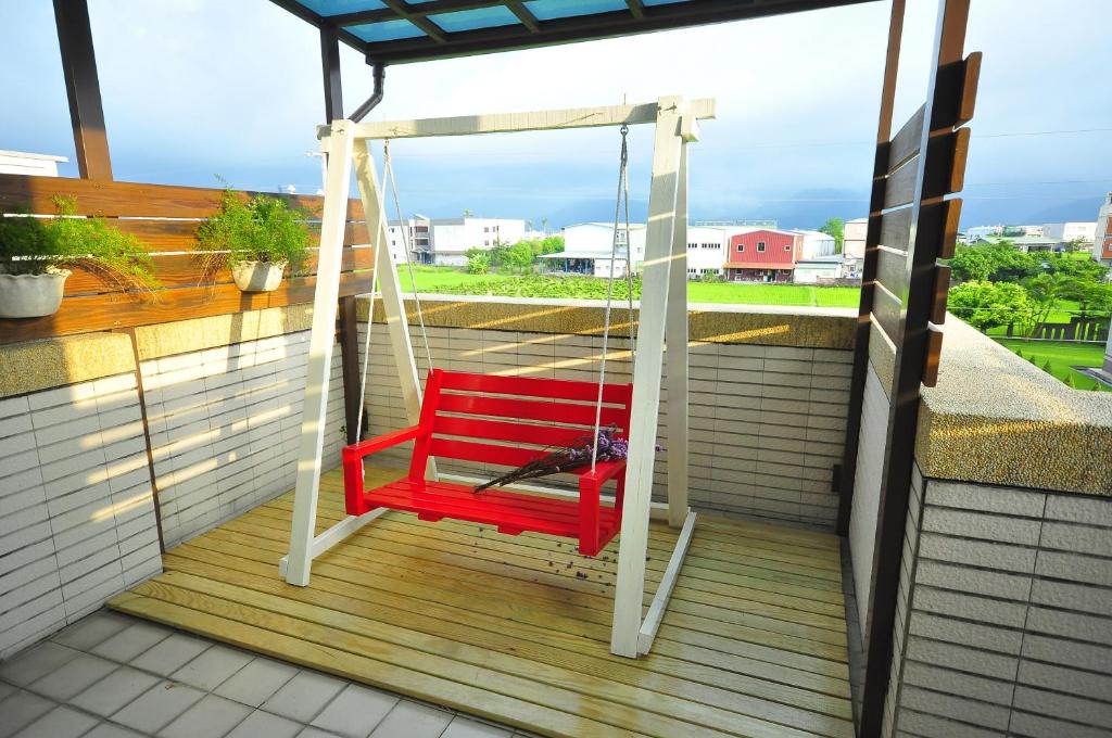 a red swing on a balcony with a bird on it at Happy Orange Homestay in Dongshan