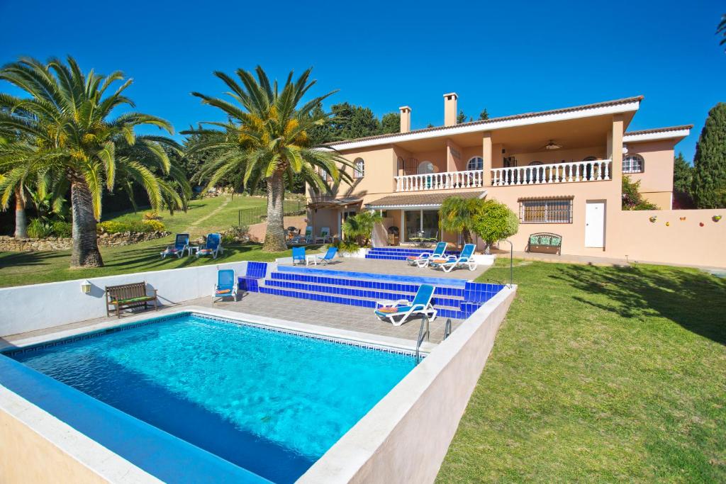 een villa met een zwembad en een huis bij Villa Tranquilla in Estepona