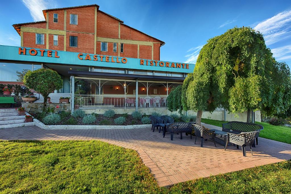 a hotel with benches in front of a building at Hotel Castello in Sovicille