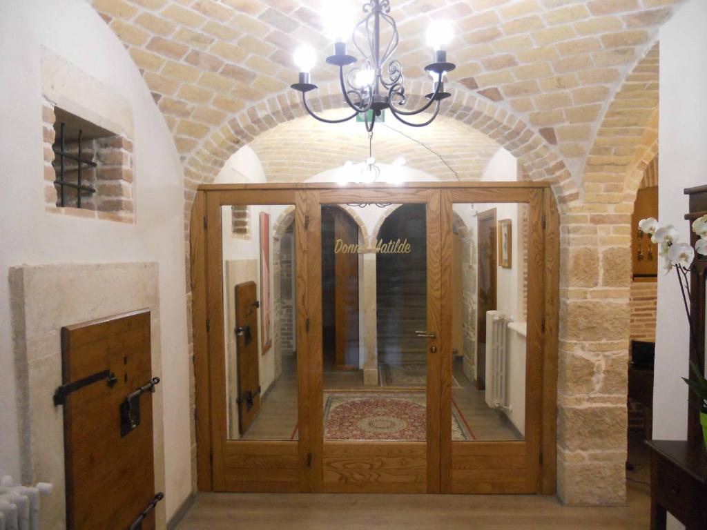um corredor com uma porta de madeira e um lustre em Donna Matilde em Pescocostanzo