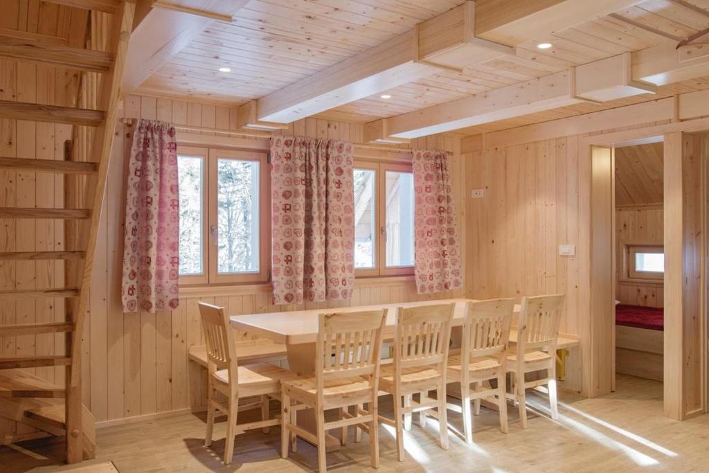 ein Esszimmer mit einem Holztisch und Stühlen in der Unterkunft Koča Predilnica Velika Planina in Kamniška Bistrica