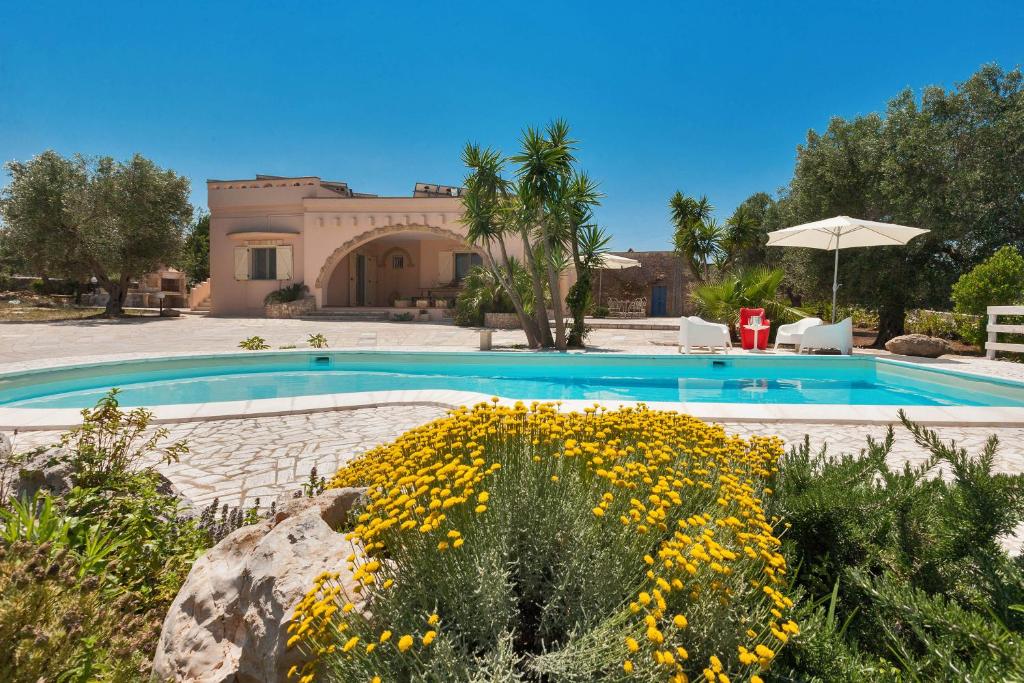 a swimming pool in front of a house at Tenuta Gianfredi by BarbarHouse in Casarano