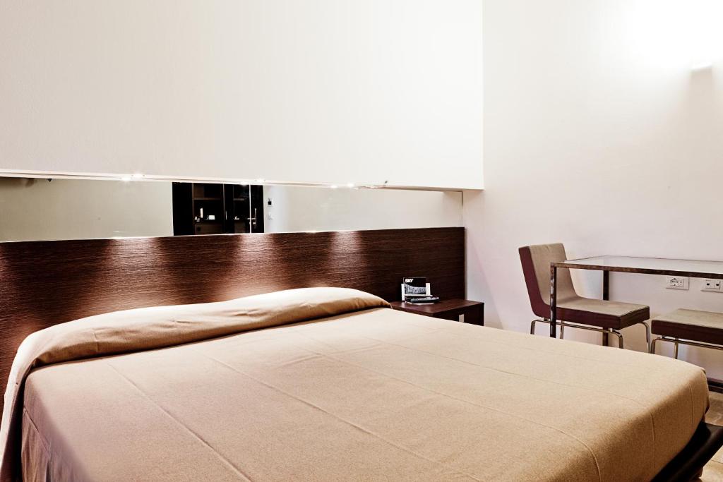 ボローニャにあるムアのベッドルーム1室(ベッド1台、テーブル、椅子付)