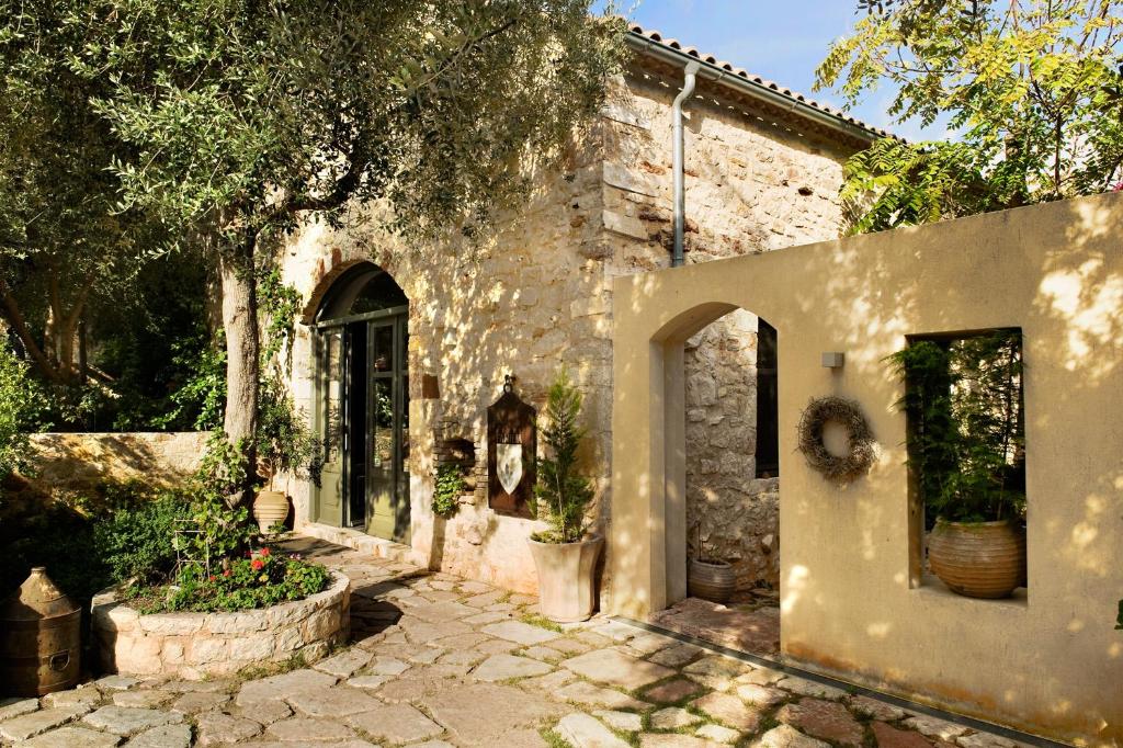 an old stone house with a stone walkway at Familia in Vathi