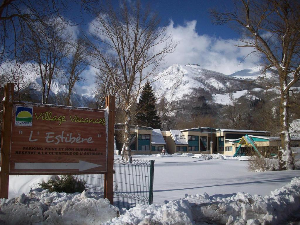 un panneau dans la neige avec une montagne en arrière-plan dans l'établissement Village Vacances Passion L'Estibère, à Vielle-Aure