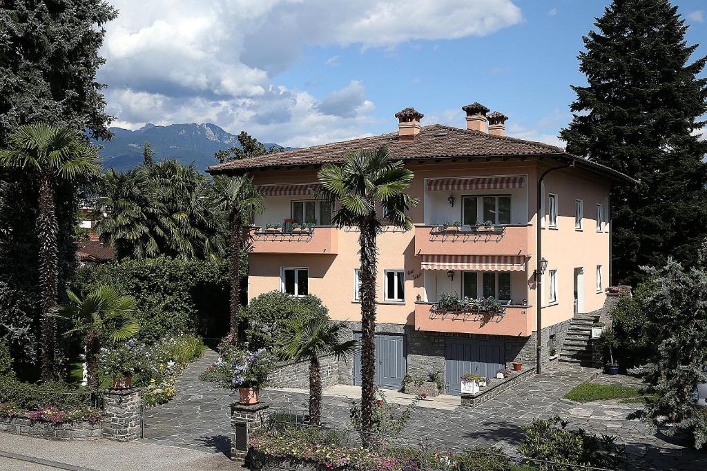 a large house with palm trees in front of it at Apartment Casa Thuja in Ascona