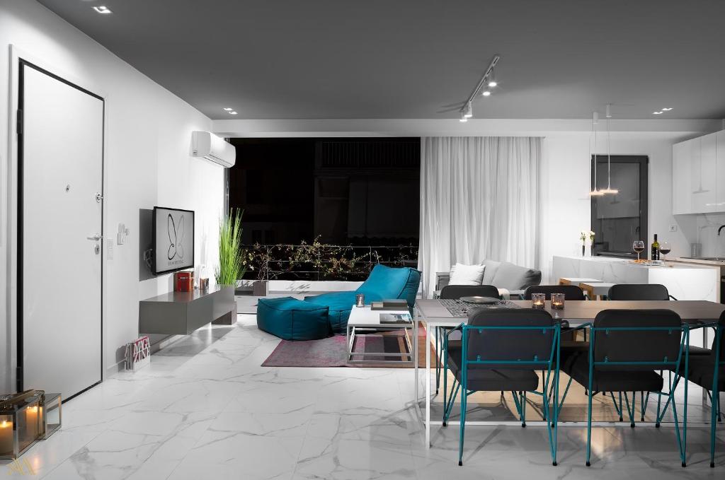 salon ze stołem i niebieskimi krzesłami w obiekcie Elysium Boutique Apartments w Atenach