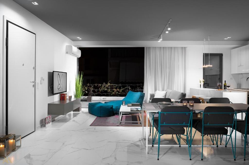 a living room with a table and blue chairs at Elysium Boutique Apartments in Athens