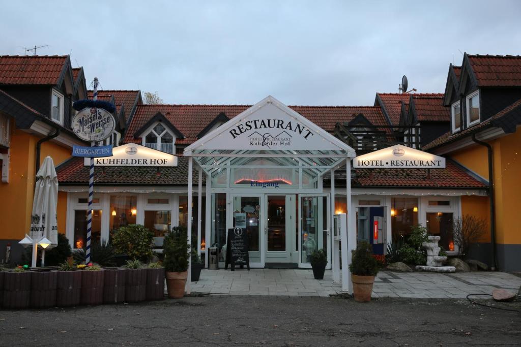 un restaurante con una señal frente a un edificio en Hotel Kuhfelder Hof en Kuhfelde