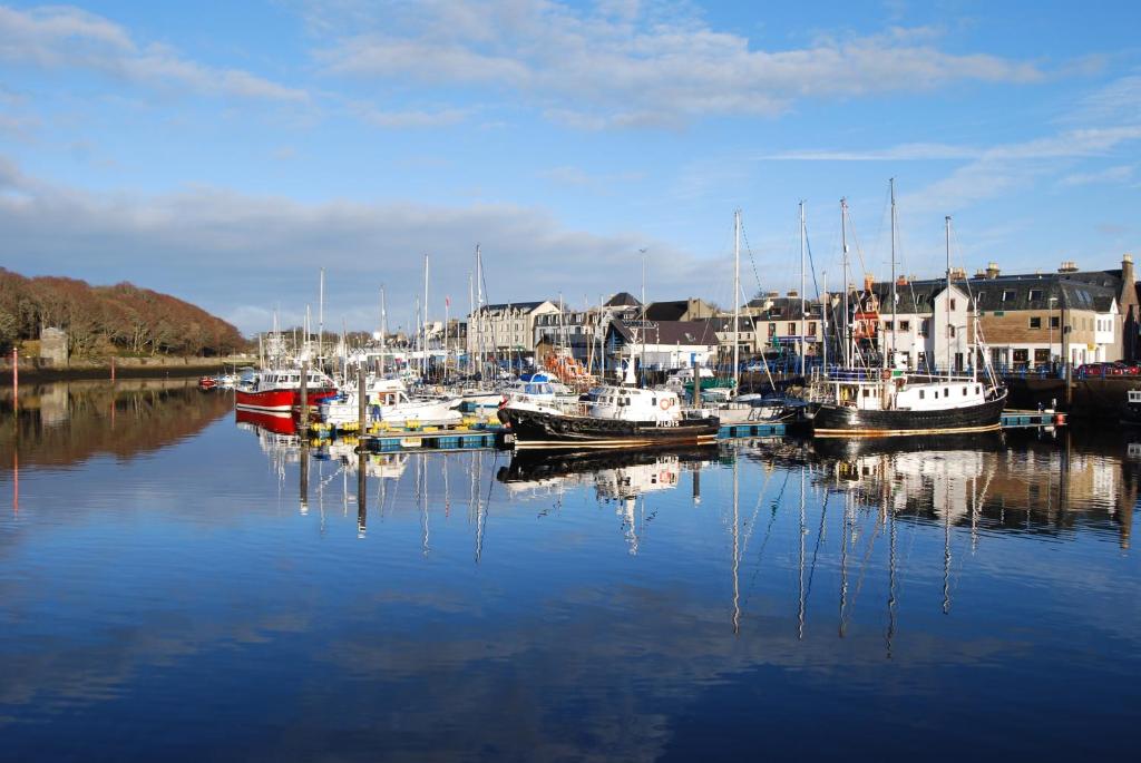 a group of boats are docked in a harbor at Stornoway Apartment in Stornoway