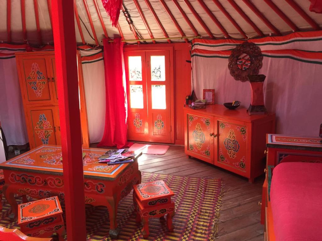 Zimmer mit einem Bett, einem Tisch und einem Fenster in der Unterkunft Au Soleil Mongol in Sorède