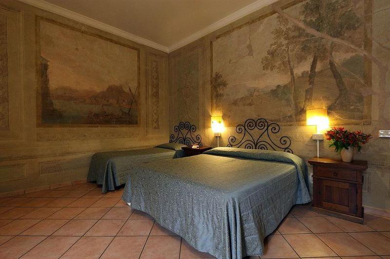 a bedroom with two beds and a painting on the wall at Hotel Bavaria in Florence