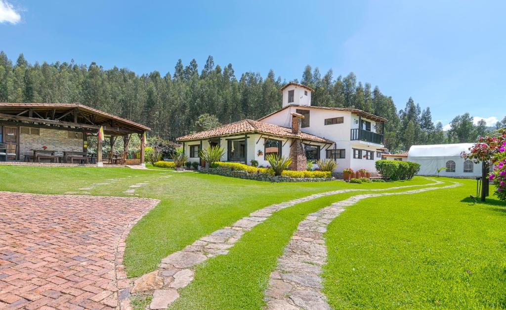 a house with a brick path leading into a yard at San Mateo Hotel Campestre in Nobsa