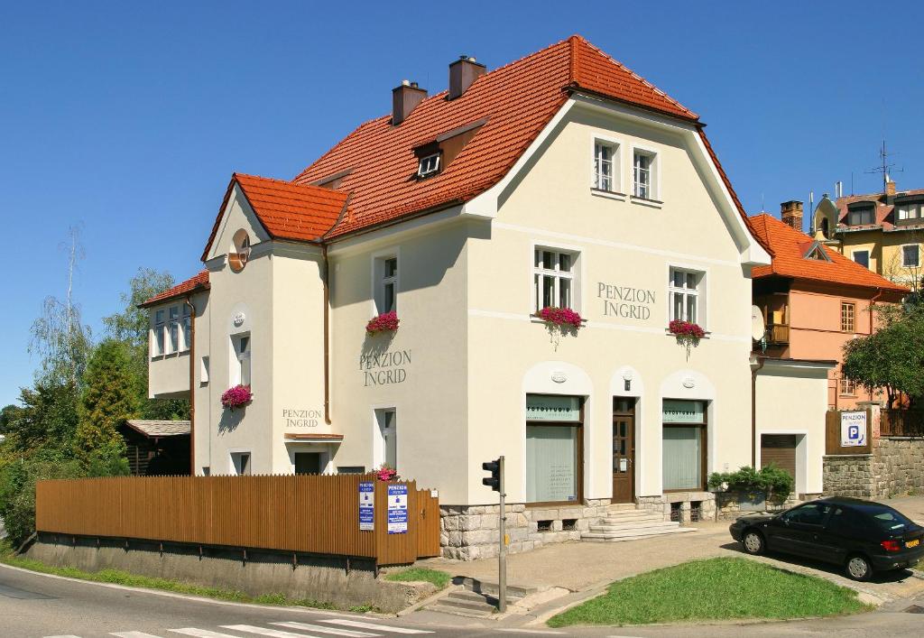 una casa blanca con techo naranja en Pension Ingrid, en Český Krumlov