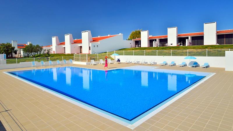 a rendering of a swimming pool in front of a building at Parque de Campismo da Ilha do Pessegueiro in Porto Covo