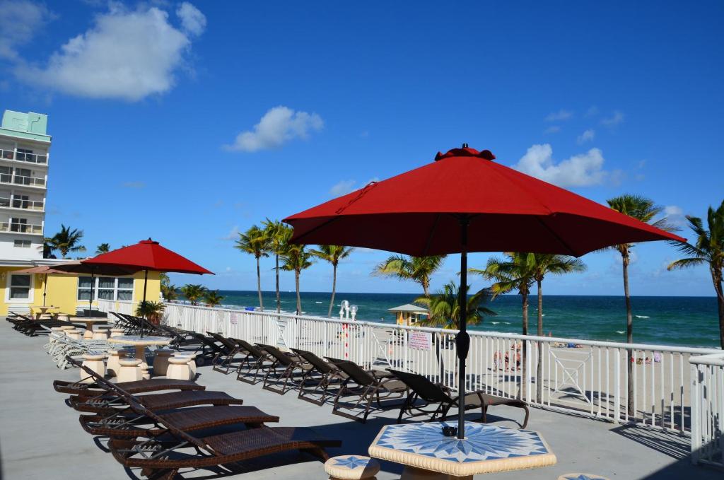 a row of chairs and an umbrella on a beach at La Terrace Oceanfront in Hollywood