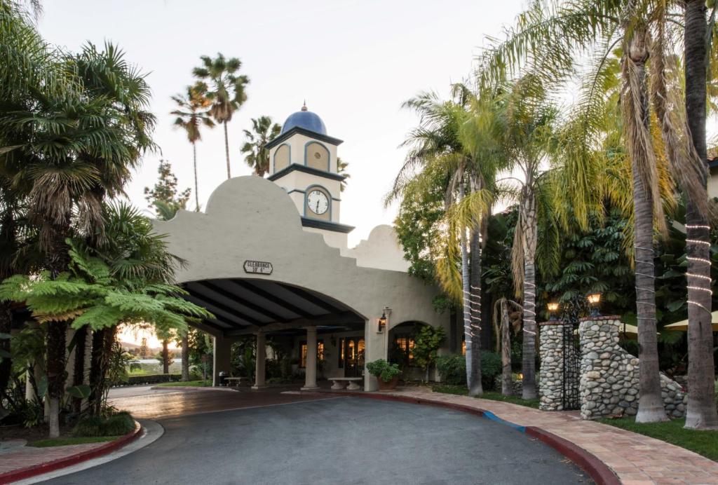a building with a clock tower and palm trees at Vanllee Hotel in Covina