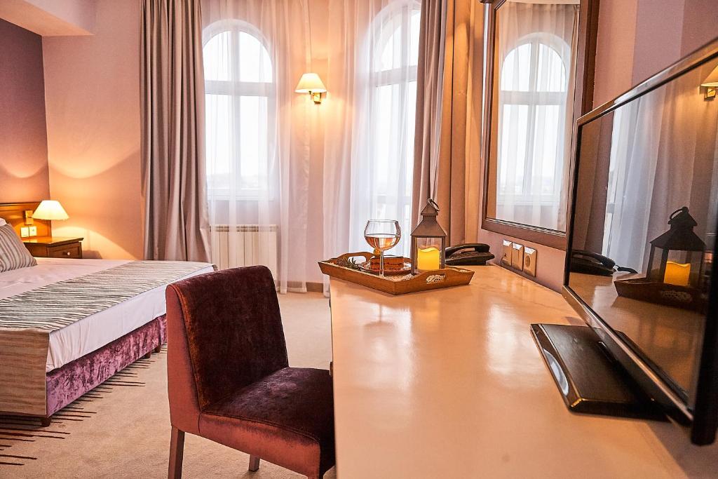 a hotel room with a bed and a desk and a chair at Hotel Lion Sofia in Sofia