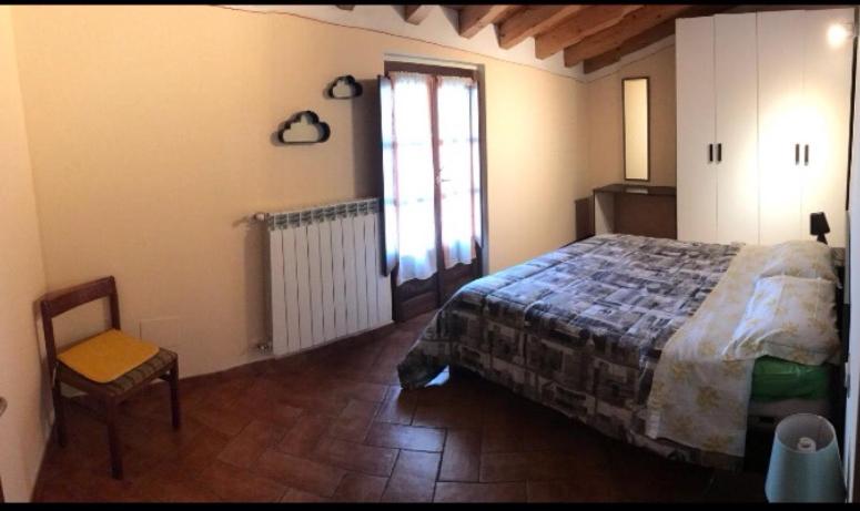 Montorfano Haus في روفاتو: غرفة نوم بسرير وكرسي ونافذة