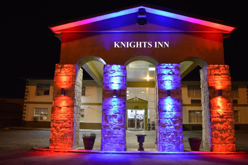um edifício com luzes roxas e azuis em frente em Knights Inn Greenville em Greenville