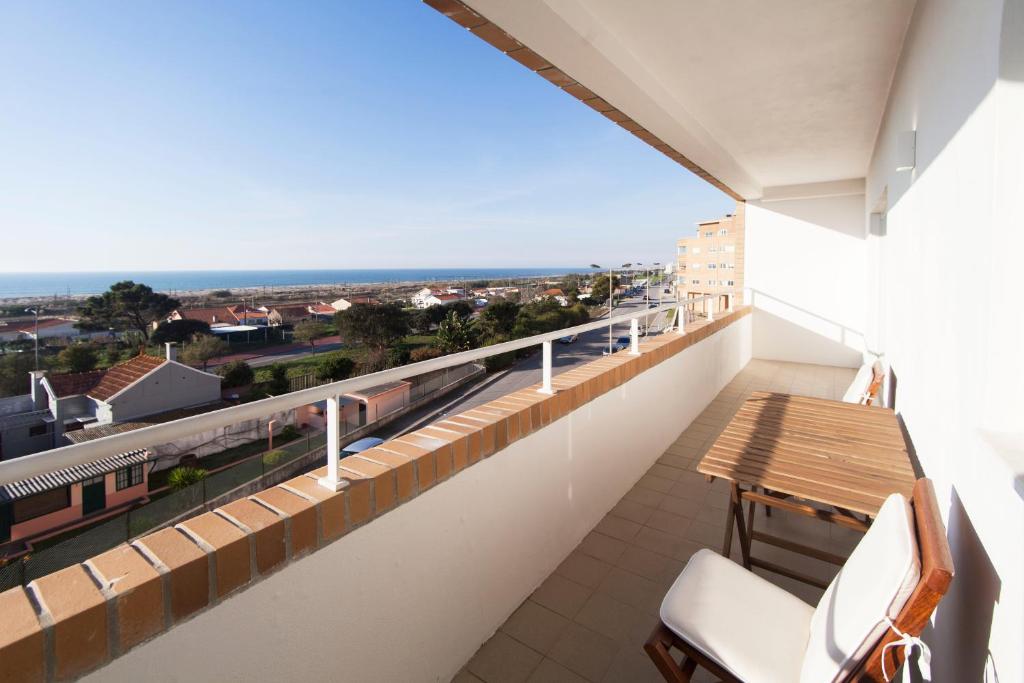a balcony with a table and chairs and a view at Sea You Espinho in São Félix da Marinha