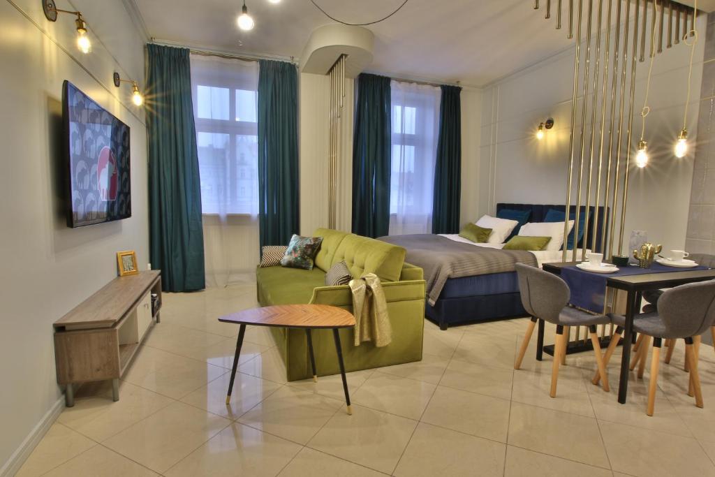 a living room with a couch and a bed and a table at Apartamenty Stary Rynek Bydgoszcz in Bydgoszcz