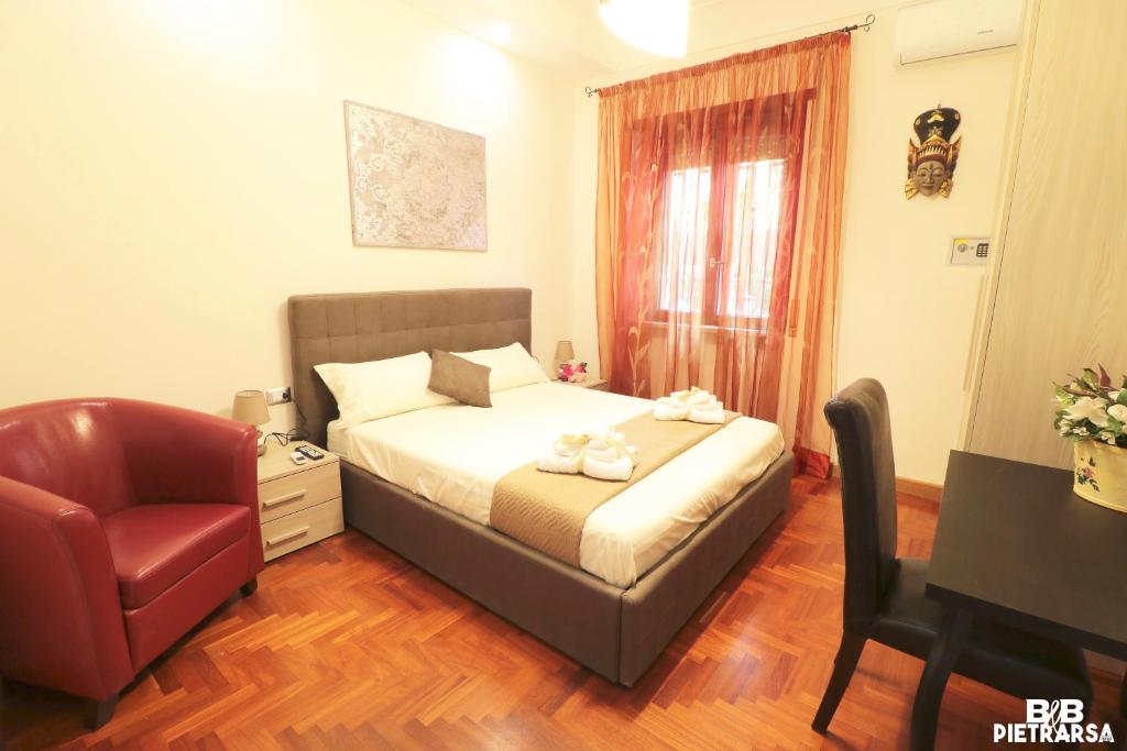 a bedroom with a bed and a chair and a desk at B&B Pietrarsa in Portici