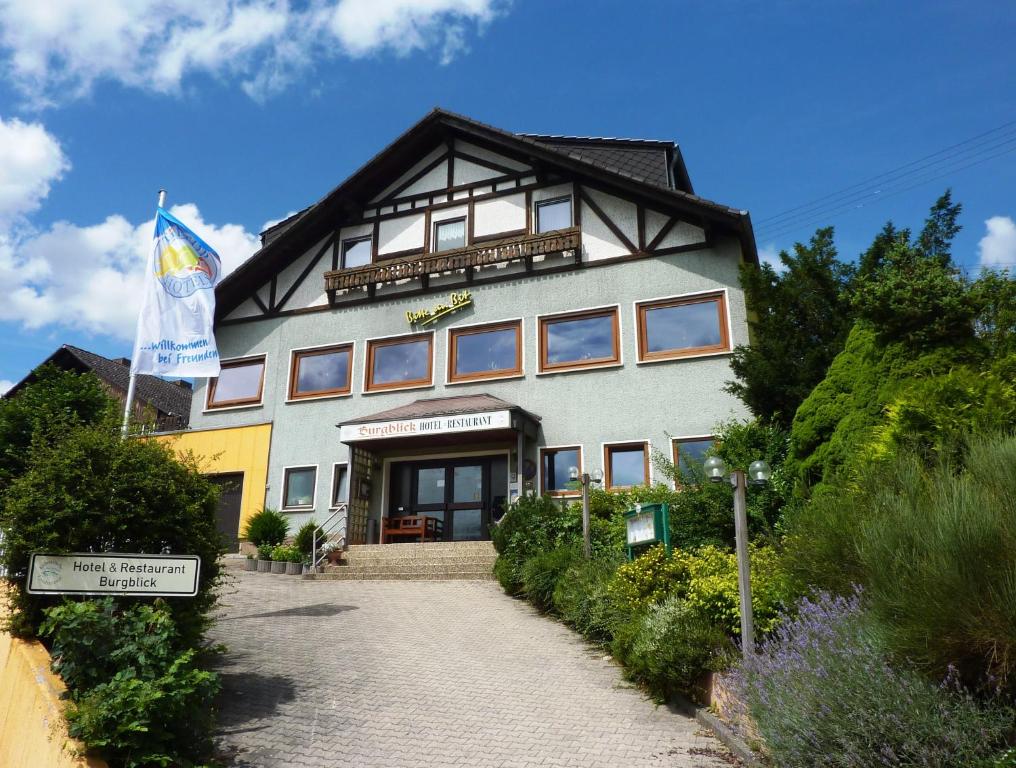 um edifício com uma bandeira à sua frente em Hotel Burgblick em Thallichtenberg