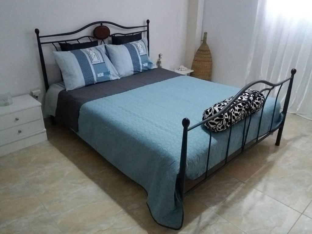 a bedroom with a large bed with blue and white pillows at Nice apartments in the center of Athens! in Athens