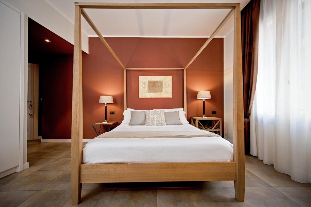 a bedroom with a four poster bed and red walls at Delle Vittorie Luxury Rooms&Suites in Palermo