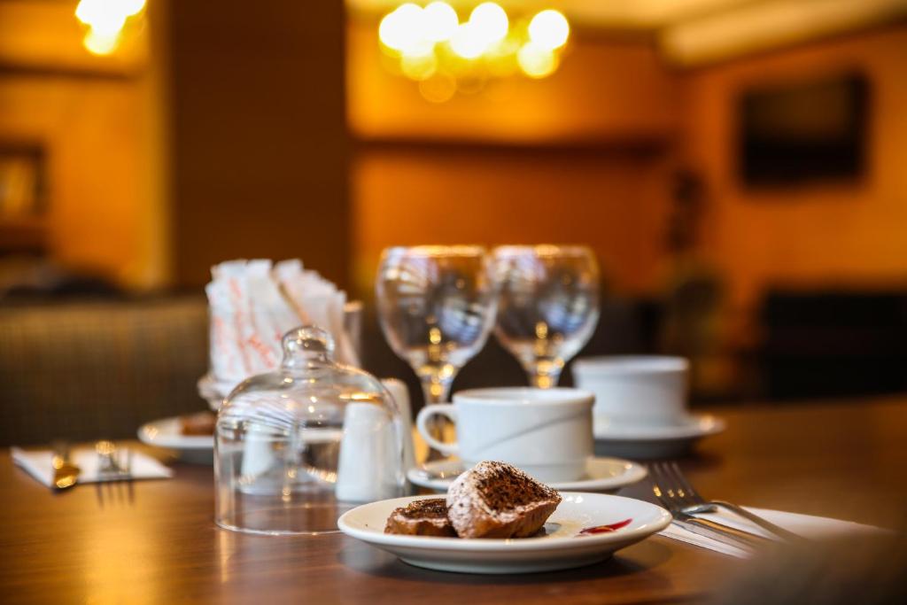 a table with plates of food and wine glasses at New Gate Hotel in Ankara