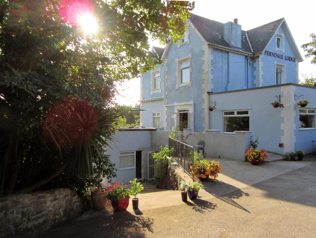 a blue and white house with flowers in front of it at Ferndale Lodge in Torquay