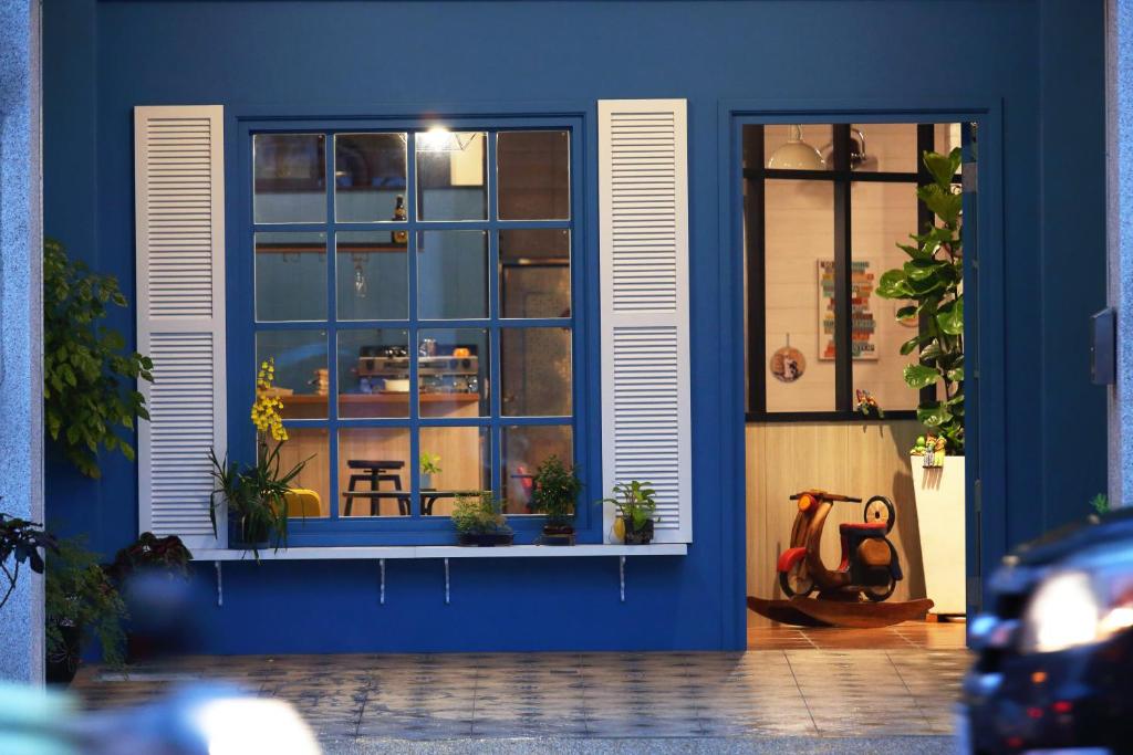 a blue building with a window with plants in it at Alien B&B in Hualien City