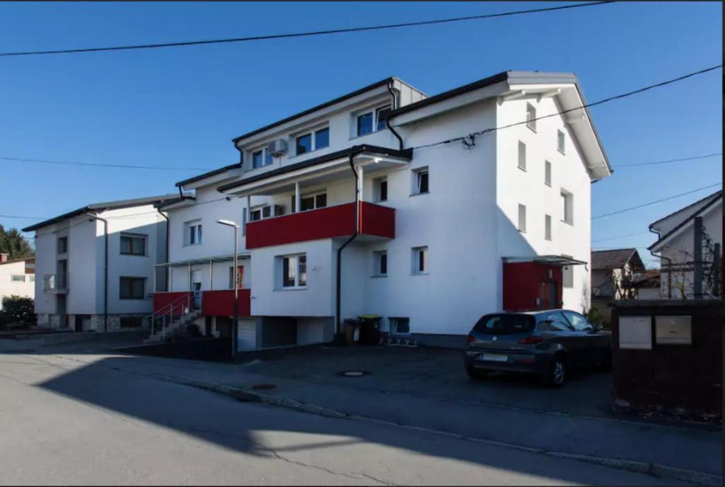 un edificio blanco con un coche aparcado delante de él en Patricia House en Liubliana