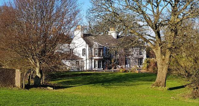 une grande maison blanche avec des arbres devant elle dans l'établissement Torrs Warren Country House Hotel, à Stoneykirk