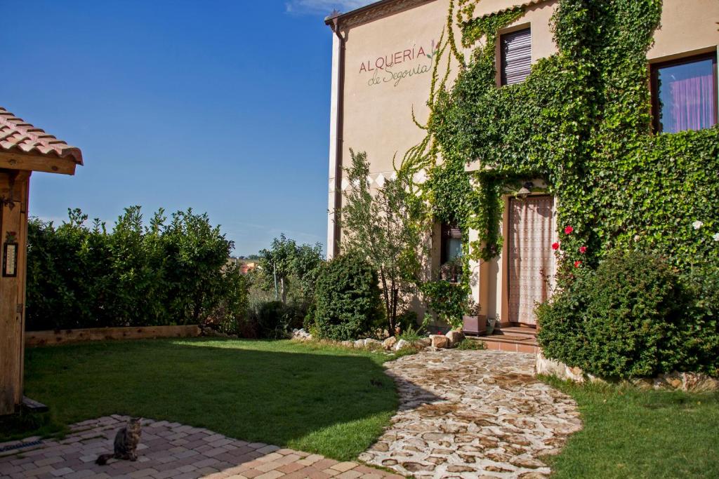 a house with ivy on the side of it at Casa Rural Alquería de Segovia in Tizneros