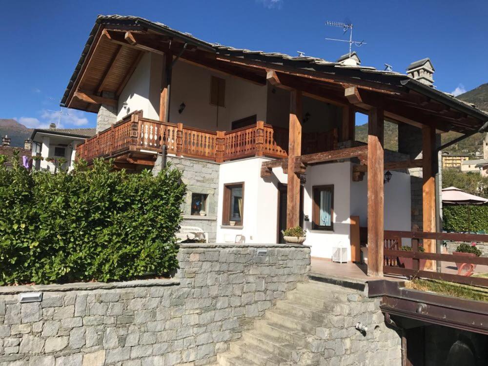 a house with a balcony on top of a stone wall at Casa tipica valdostana in Aosta