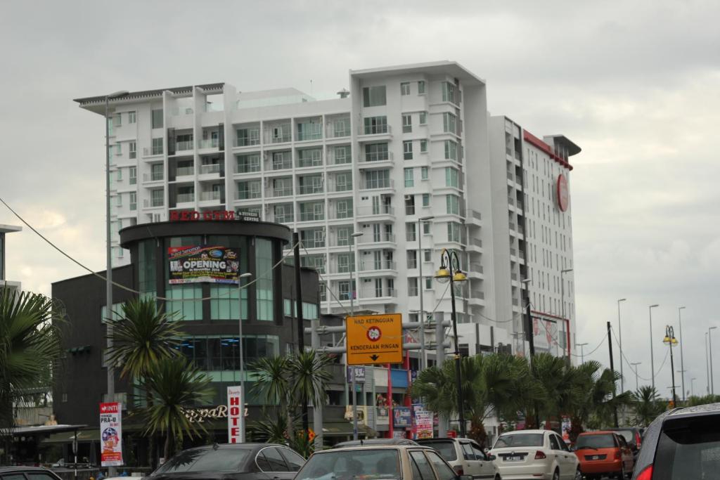 ein großes weißes Gebäude mit Autos in einer Stadt in der Unterkunft Taiping Centre Point Suite in Taiping